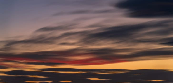Stunning long-exposure photo of a sunset sky transitioning from blue to orange, perfect for backgrounds with text space.