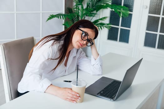Business woman tired of working on laptop in office