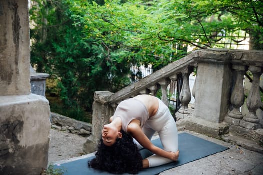 Woman doing yoga exercises outdoors on the bridge