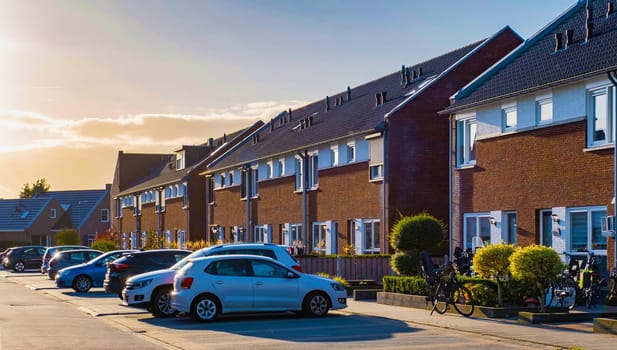 Dutch Suburban area with modern family houses, newly built modern family homes in the Netherlands, dutch family houses in the Netherlands, row of newly built houses in the Netherlands at sunset