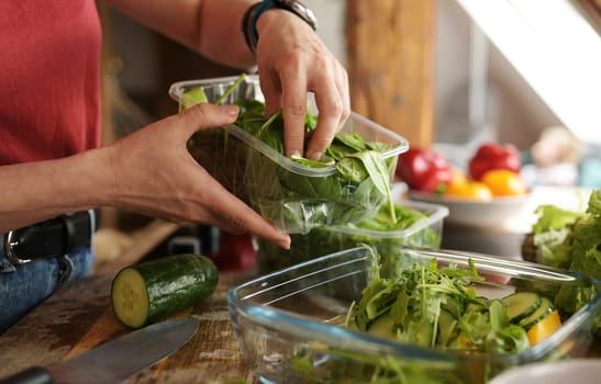 Girl Adding A Fresh Greens And Arugula To Fresh Vegetable Salad In The Bowl In The Kitchen