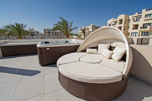 Roof terrace patio furniture at a luxury holiday villa in tropical resort with sun lounger chair and hot tub