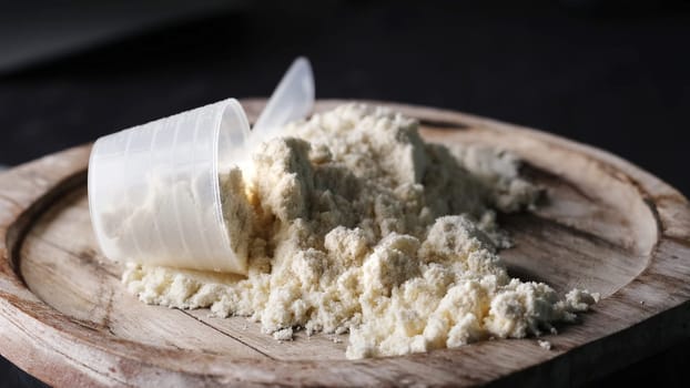 Scoop with whey protein powder on board, supplements for bodybuilding and healthy body