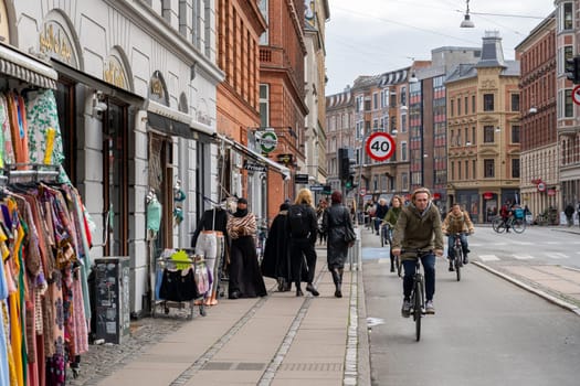 Copenhagen, Denmark - October 18, 2022: People, bicycles and shops on Norrebrogade in Norrebro district