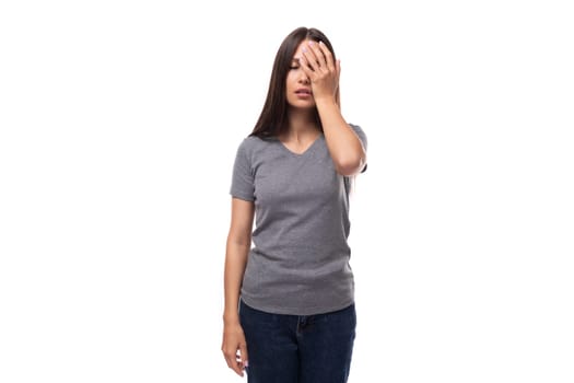 young tired brunette woman dressed in a gray basic t-shirt with print mockup. uniform concept.