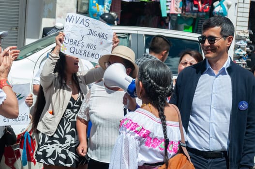 macho man laughing at demonstrators in a demonstration against gender violence. indigenous women in an anti macho demonstration. women's day. High quality photo