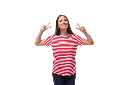 young positive smiling european woman with straight black hair in a striped red t-shirt on a white background.