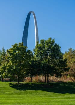 View across green planting of Explorers park to Gateway Arch and trail in downtown St Louis Missouri