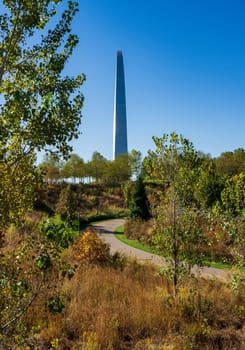 View across green planting of Explorers park to Gateway Arch and trail in downtown St Louis Missouri