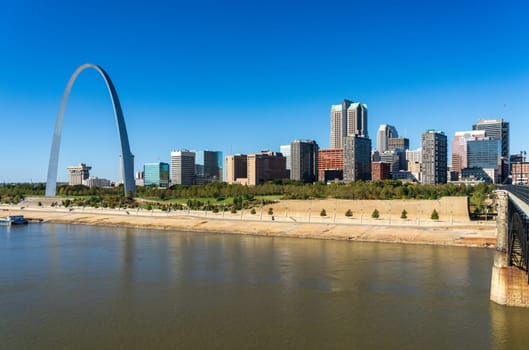 St Louis, MO - October 21, 2023: Low water levels in Mississippi river give unusual view of Gateway arch towering over riverbank seen from Eads Bridge