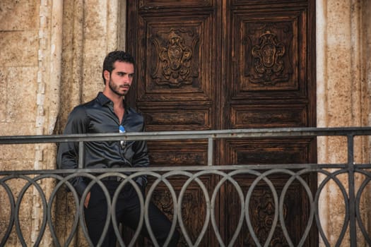 A man standing in front of a wooden door. The Mysterious Man at the Enchanted Wooden Door and Behind a Metal Hand-Rail