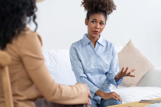 Sad PTSD woman patient in crucial therapy for mental health with psychologist, depression or grief after life failure. Frustrated trauma young woman talking to a psychologist about emotion in clinic