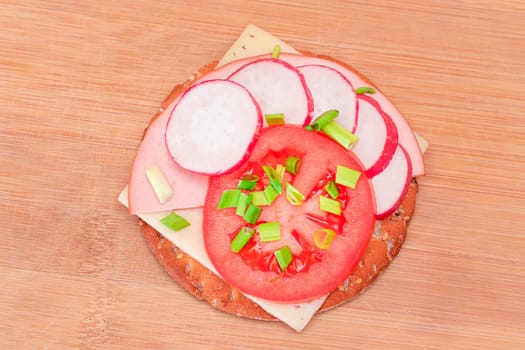 Crispy Cracker Sandwich with Tomato, Sausage, Cheese, Green Onions and Radish on Cutting Board. Easy Breakfast. Quick and Healthy Sandwiches. Crispbread with Tasty Filling. Healthy Dietary Snack