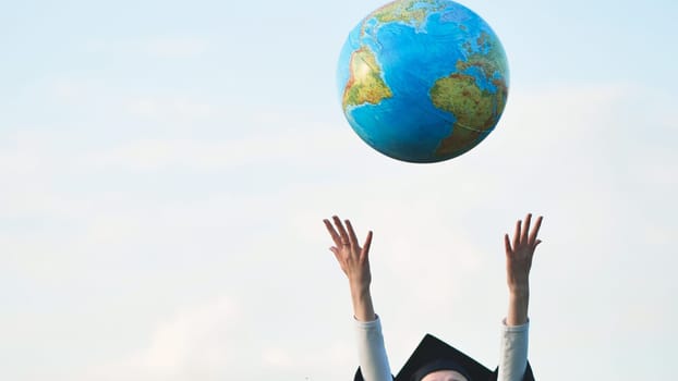 Graduate girl tosses the globe up