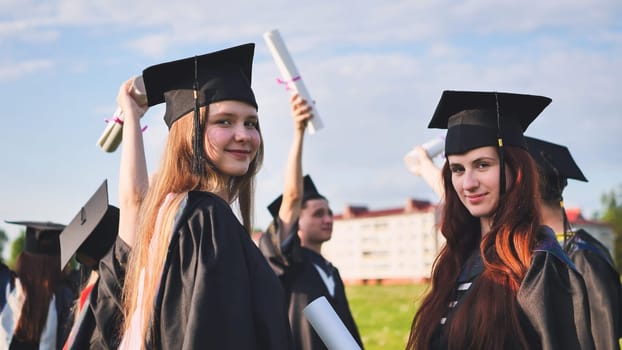 Portraits of graduating girls in black robes on the street