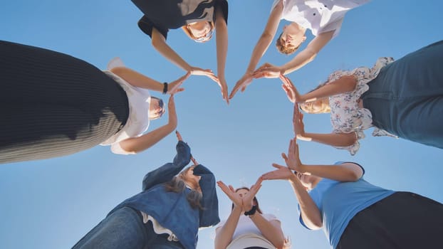 School children make a heart shape from their hands