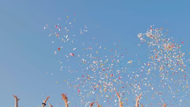 Tossing colorful paper confetti from the hands of young people