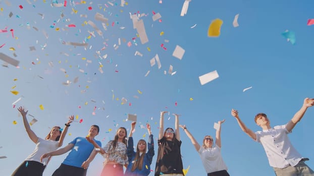 Friends toss colorful paper confetti from their hands