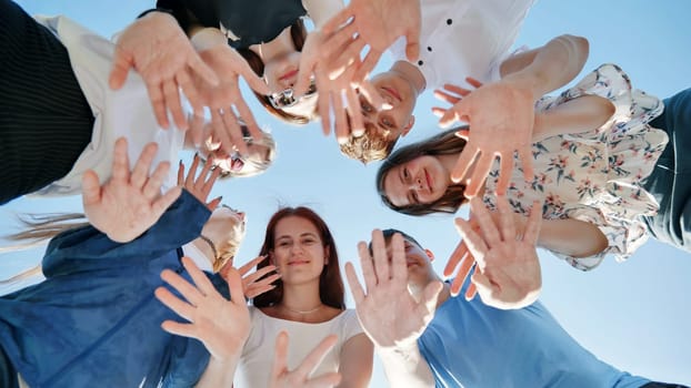 The young friends stand in a circle and wave their hands