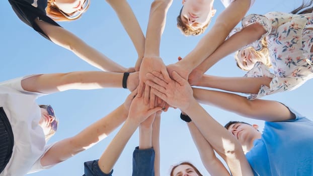 Friends putting their hands together in a sign of unity and teamwork. Just the hands