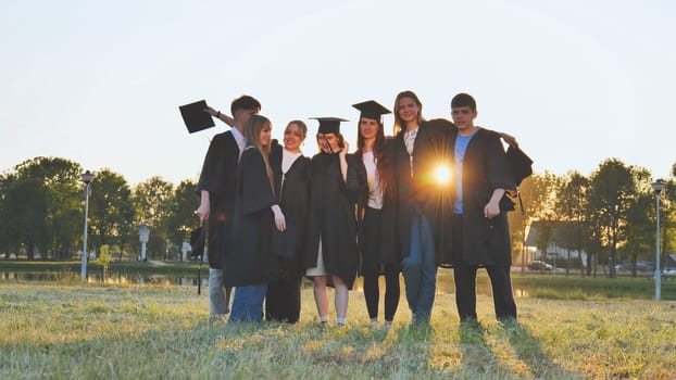 Student alumni waving at sunset