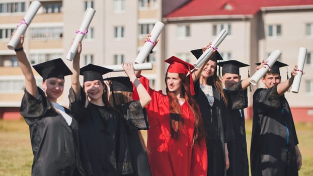 group of multiracial graduates holding diploma