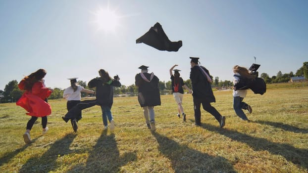 Happy Students with congratulations throwing graduation hats in the air for celebrating