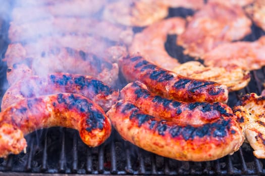 Pork meat and sausages grilled on a charcoal barbeque. Top view of tasty barbecue, food concept, food on grill and detail of food on the grill