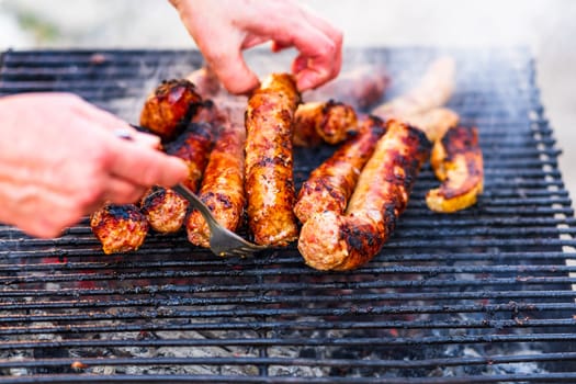 Grilling sausages on barbecue grill. Delicious sausages on charcoal grill