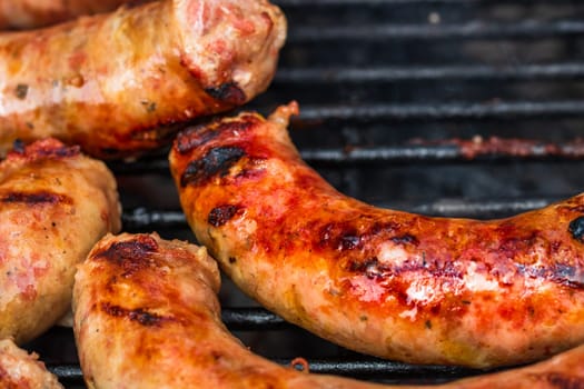 Close up on details of homemade sausages on barbecue grill. Barbecue, grill and food concept.