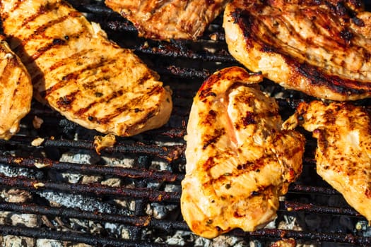 Chicken and pork steak grilled on a charcoal barbeque. Top view of camping tasty barbecue, food concept, food on grill and detail of food on the grill