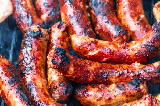 Close up on details of homemade sausages on barbecue grill. Barbecue, grill and food concept.