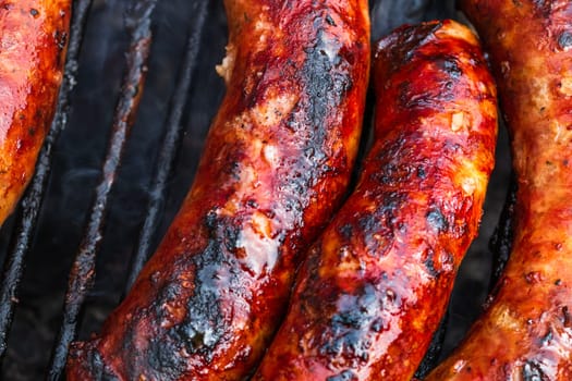 Close up on details of homemade sausages on barbecue grill. Barbecue, grill and food concept.