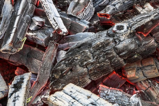 Burning wood chips forming coal. Barbecue preparation, fire before cooking. Hot coal made of greatly heated wood.