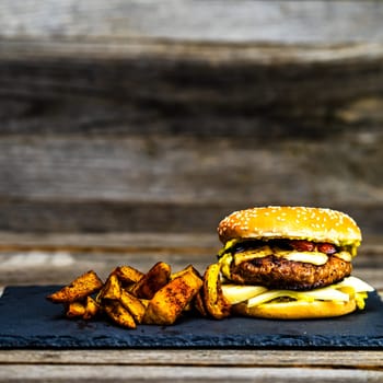 Tasty home made cheeseburger. Cheese burger with pickles, tomatoes, onion, melting cheese