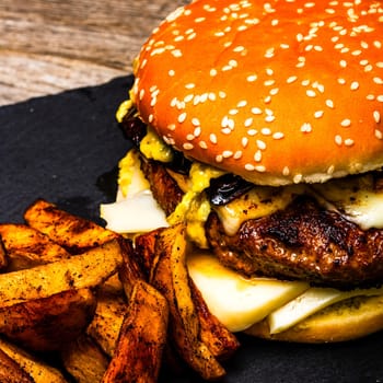 Tasty home made cheeseburger. Cheese burger with pickles, tomatoes, onion, melting cheese