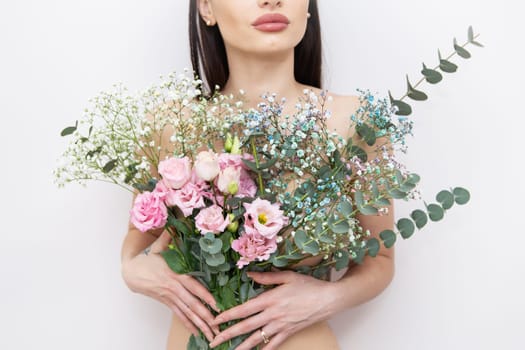 The girl's hands are holding a very beautiful spring bouquet of flowers: pink eustoma, gypsophila multicolored, eucalyptus. Flower composition. Spring, 8 March