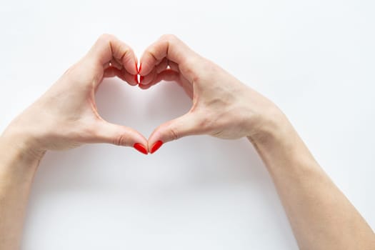 Female hands in the shape of a heart isolated on white background. The concept of care and love