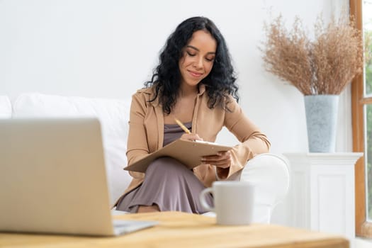 African-American woman using laptop computer for crucial work on internet. Secretary or online content writing working at home.