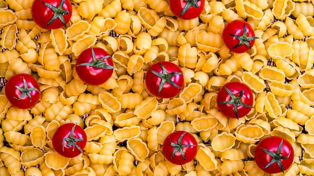 Food background with ripe cherry tomatoes on gnocchi raw pasta bed.