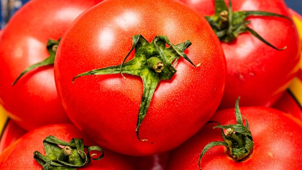 Close up of ripe red tomato, tomatoes background.