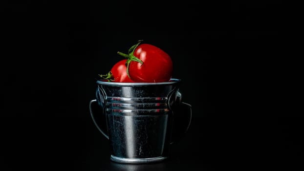 Selective focus on composition with mini decorative bucket and tomatoes. Small metal bucket with cherry tomatoes