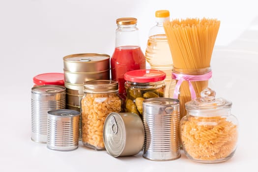 Food Reserves: Canned Food, Spaghetti, Pate, Tuna, Tomato Juice, Pasta, Fish and Grocery on White Background. Emergency Food Storage in Case of Crisis. Strategic Food Supplies