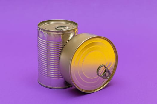 Unopened Tin Cans with Blank Edge on Violet Background. Canned Food. Aluminum Cans for Safe and Long Term Storage of Food. Steel Sealed Food Storage Containers