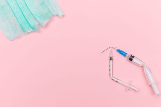 Anti Vaccine Movement and Anti Mask Concept - Broken Medical Syringe and Green Torn Medical Face Mask on the Pink Background. Pandemic and Lockdown End - Top View, Flat Lay