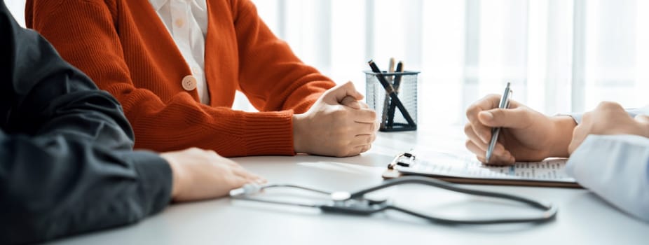 Couple attend fertility consultation with gynecologist at hospital as part family planning care for pregnancy. Loving husband and wife support each other through the doctor appointment. Panorama Rigid