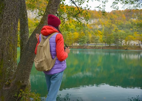 Travel. The girl travels through the mountains and waterfalls of the wild. Unity, mental health, eco-travel. Hiking, traveling, good times, digital detox.