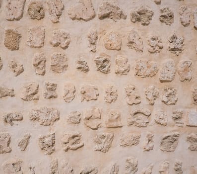 Traditional stone, coral and adobe wall in Sharjah emirate in the United Arab Emirates. Such hand plastered walls were made for centuries in the Arabian Gulf with materials from the desert and sea