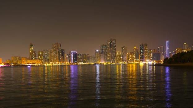 Night landscape of the embankment of the emirate of Sharjah, United Arab Emirates.