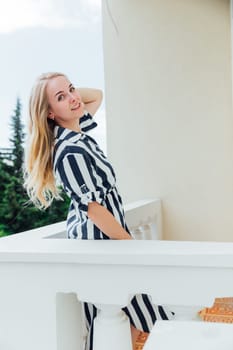 Portrait of a beautiful blonde woman in a striped summer dress